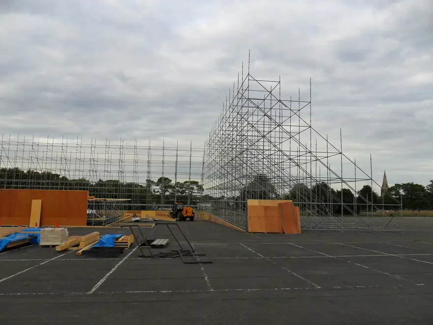 Free-standing scaffold backdrop braced by raking supports at a film set in Aldershot