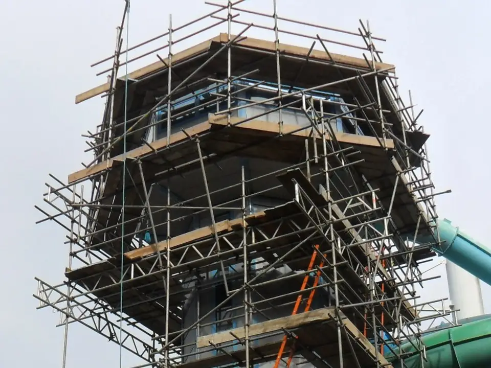 Scaffold platforms stepping out around the top of the Coral Reef flume tower in Bracknell
