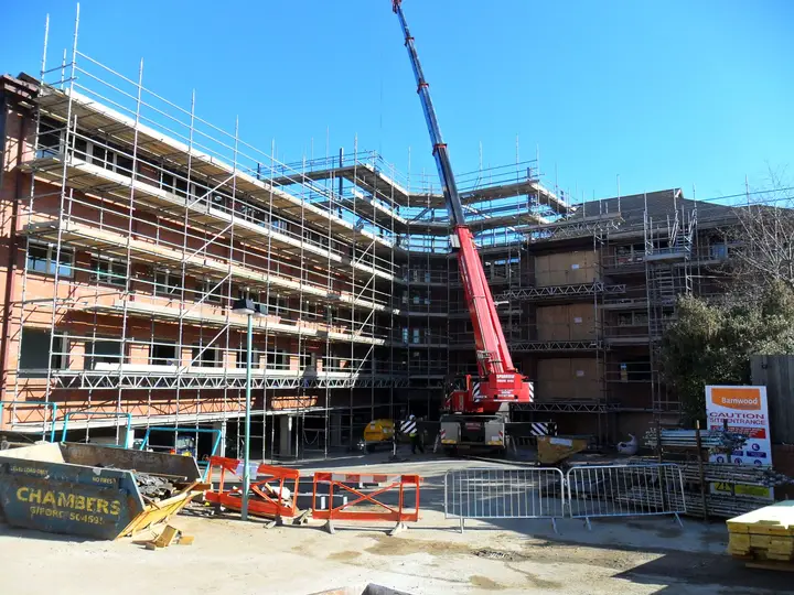 Scaffold around the courtyard of a new hotel in Guildford with a mobile crane lifting