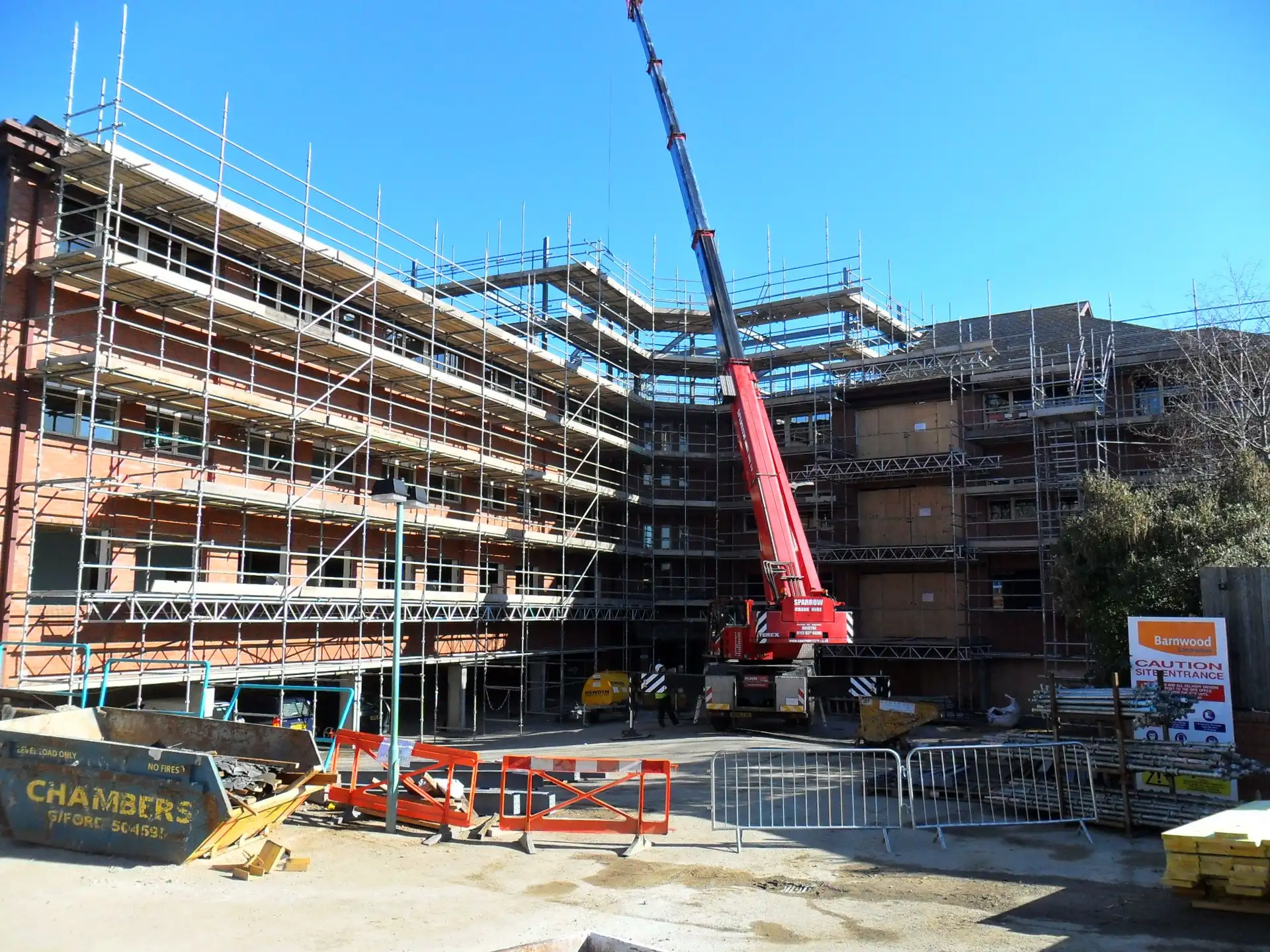 Scaffold around the courtyard of a new hotel in Guildford with a mobile crane lifting