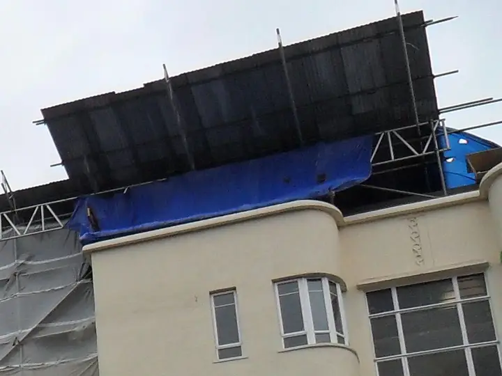 Trussed beams and roof sheets of a temporary roof on an apartment block in High Wycombe