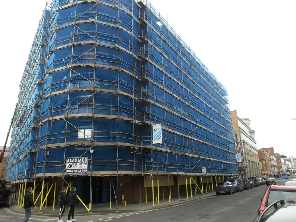 Multi-storey scaffolding with blue debris netting on an office block in Maidenhead town centre