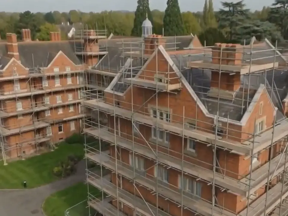 Aerial view of scaffolding around red-brick Oxford college buildings with gabled roofs